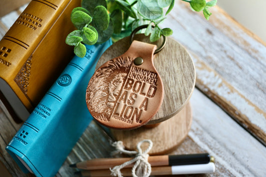 Unmoved. Unshaken. BOLD AS A LION. (Proverbs 28:1) leather keyring (camel/natural)
